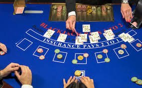 Dealer langsung di studio lapak slot menyiarkan permainan baccarat dengan kartu di tangan